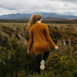 Frau auf Feld mit nordischem Hintergrund